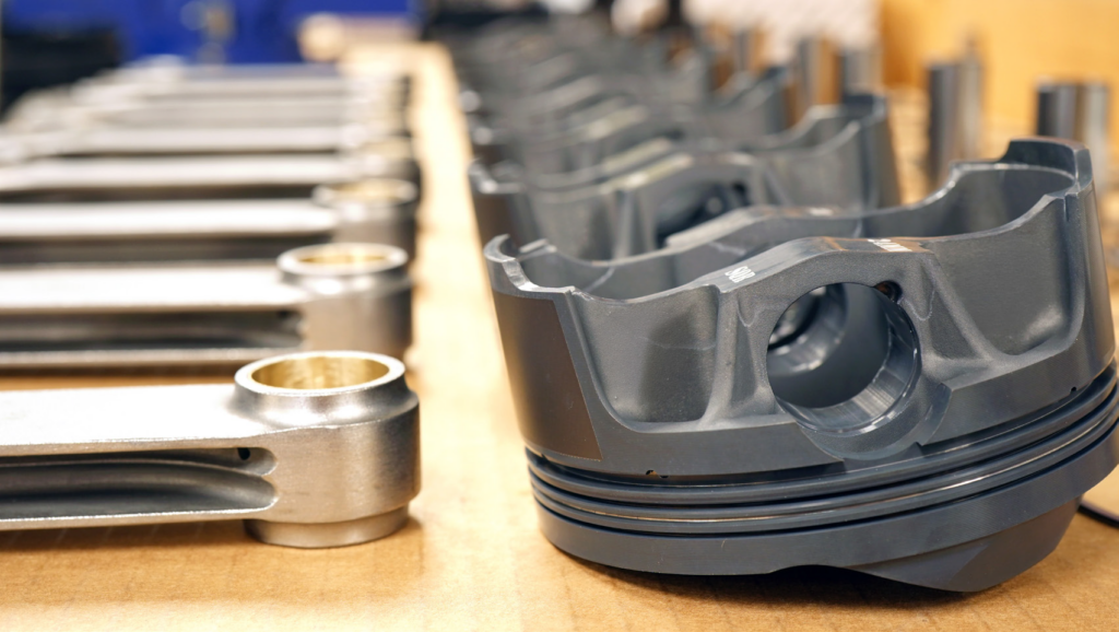 row of pistons & connecting rods on table